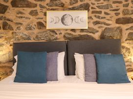 A bedroom with a bed and wall art at Bwthyn Y Bugail (Shepherd's Cottage) Pedairffordd near Llanrhaeadr-Ym-Mochnant