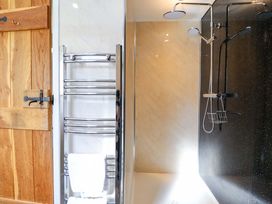 A bathroom with a shower and towel rail at Bwthyn Y Bugail (Shepherd's Cottage) Pedairffordd near Llanrhaeadr-Ym-Mochnant