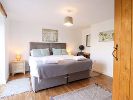 A bedroom with a bed and bedside table at Bwthyn Y Bugail (Shepherd's Cottage) Pedairffordd near Llanrhaeadr-Ym-Mochnant