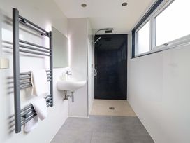 A bathroom with a towel radiator and sink at Bwthyn Y Bugail (Shepherd's Cottage) near Pedairffordd near Llanrhaeadr-Ym-Mochnant