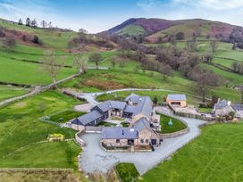 A rural property with multiple buildings and green fields at Bwthyn Y Bugail (Shepherd's Cottage) Pedairffordd near Llanrhaeadr-Ym-Mochnant