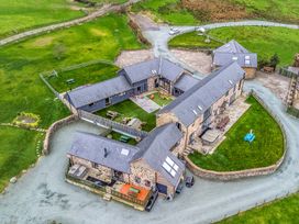 An outdoor area with buildings and garden furniture at Y Beudy (The Dairy) Pedairffordd near Llanrhaeadr-Ym-Mochnant