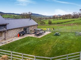An outdoor space with a table and chairs at Y Granar (The Granary) Llanrhaeadr-Ym-Mochnant