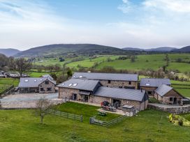 An outdoor view of a farmhouse with surrounding fields at Y Stabl (The Stable) Llanrhaeadr-Ym-Mochnant