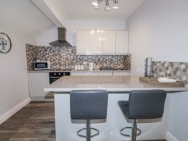 A kitchen with bar stools and appliances at The Wren in Llysfaen