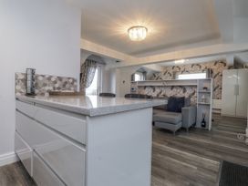 A kitchen with a countertop and bar stools at The Wren in Llysfaen