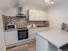 A kitchen with modern appliances including a microwave and oven at The Wren in Llysfaen