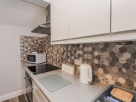 A kitchen with a microwave and electric stove at The Wren in Llysfaen