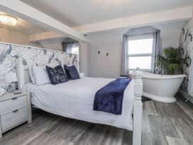 A bedroom with a bed and bathtub at The Wren in Llysfaen