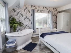A bathroom with a bathtub and towels at The Wren in Llysfaen