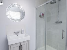 A bathroom with a shower and washbasin at The Wren in Llysfaen
