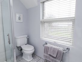 A bathroom with a toilet and shower at The Wren in Llysfaen