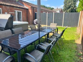 A garden with a table and chairs near a hot tub at Sunnymeade in Buxton, Norfolk
