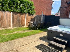 A garden with a hot tub and a dining area at Sunnymeade in Buxton, Norfolk
