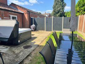 A garden with a hot tub, table and chairs at Sunnymeade, Buxton, Norfolk
