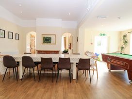 A dining room with a table and chairs and a pool table at Sunnymeade in Buxton, Norfolk