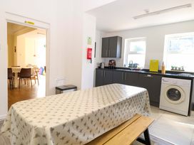 A kitchen with a table and washing machine at Sunnymeade in Buxton, Norfolk