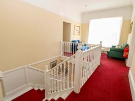 A staircase leading to a hallway with chairs at Sunnymeade in Buxton, Norfolk