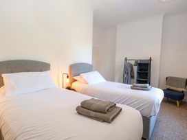 A bedroom with two single beds and a clothes rack at Sunnymeade in Buxton, Norfolk