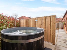 A hot tub and wooden fence in a garden at Plough Cottage Little Kelk near Bridlington