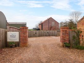 An outdoor area with a sign and gravel driveway at Kelk Beck Cottages in Little Kelk near Bridlington