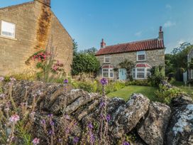 A house with a garden and stone wall at Bute Cottage Lockton near Pickering