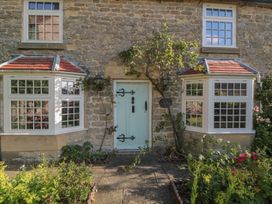 A stone cottage facade with green door and windows at Bute Cottage Lockton near Pickering