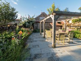 A garden with a stone patio and seating area at Bute Cottage Lockton near Pickering