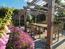 A garden with a wooden pergola and dining set at Bute Cottage Lockton near Pickering