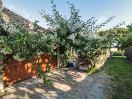 A garage with a gate and flowering plants in front at Bute Cottage Lockton near Pickering
