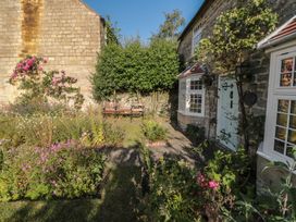 A garden with flowers and a bench at Bute Cottage Lockton near Pickering