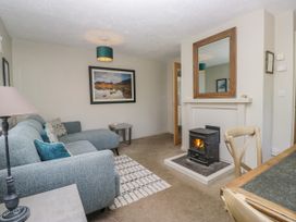 A living room with a fireplace and sofa at Windermere at the Graythwaite Estate near Hawkshead