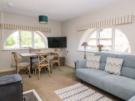 A living room with a dining table and sofa at Windermere at the Graythwaite Estate near Hawkshead