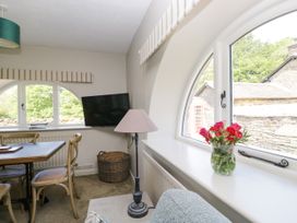 A dining room with a table, chairs, and a television at Windermere at the Graythwaite Estate near Hawkshead