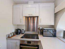 A kitchen with a cooktop and microwave at Windermere at the Graythwaite Estate near Hawkshead