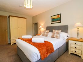 A bedroom with a bed and wardrobe at Windermere at the Graythwaite Estate near Hawkshead