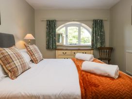 A bedroom with a bed and window at Windermere at the Graythwaite Estate near Hawkshead