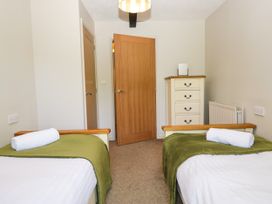 A bedroom with two single beds and a dresser at Windermere at the Graythwaite Estate near Hawkshead
