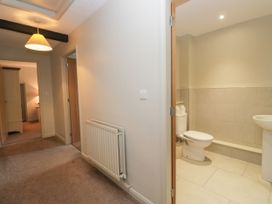 A hallway leading to a bathroom with a toilet and sink at Windermere at the Graythwaite Estate near Hawkshead