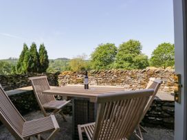 An outdoor seating area with a table and chairs at Windermere at the Graythwaite Estate near Hawkshead