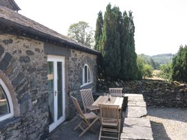 An outdoor seating area with a table and chairs at Windermere at the Graythwaite Estate near Hawkshead