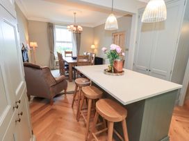 A kitchen with a dining area and bar stools at High Torver House in Torver
