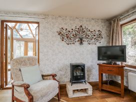 A living room with a chair and a television at Calcott Annexe in Whitchurch, Herefordshire