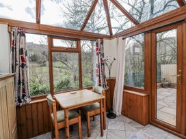 A conservatory with a table and chairs at Calcott Annexe in Whitchurch, Herefordshire