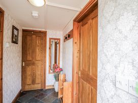 A hallway with a mirror and flower vase at Calcott Annexe in Whitchurch, Herefordshire