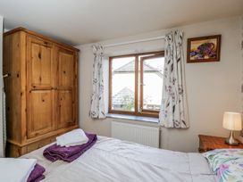 A bedroom with a wardrobe and window at Calcott Annexe Whitchurch, Herefordshire