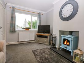 A living room with a television and a blue stove at Pebbles Reach in Colwyn Bay