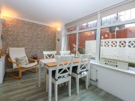 A dining room with a table and chairs at Pebbles Reach in Colwyn Bay