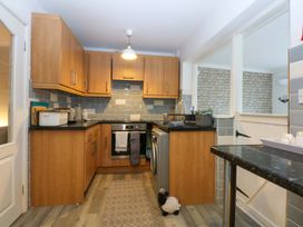 A kitchen with wooden cabinets and appliances at Pebbles Reach in Colwyn Bay