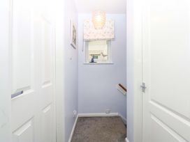 A hallway with a window and stairs at Pebbles Reach in Colwyn Bay